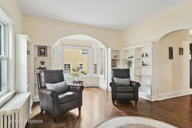 625 Greenbriar Ln, Lake Forest, IL 60045 - living area featuring arched walkways, radiator, healthy amount of natural light, and hardwood / wood-style floors