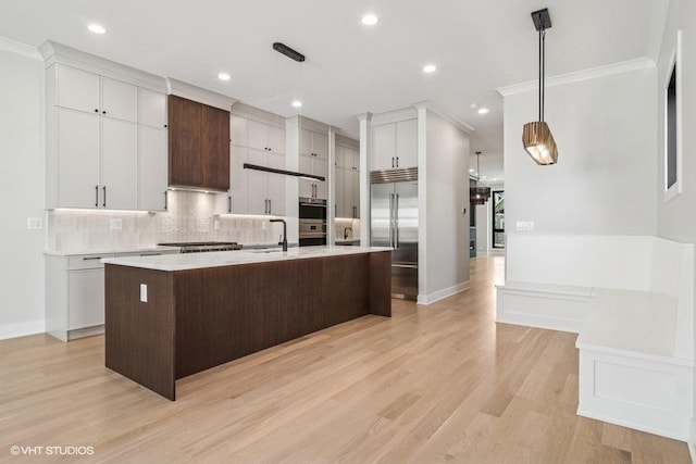1928 W George St, Chicago, IL 60657 - kitchen with stainless steel built in refrigerator, light countertops, decorative backsplash, crown molding, and an island with sink