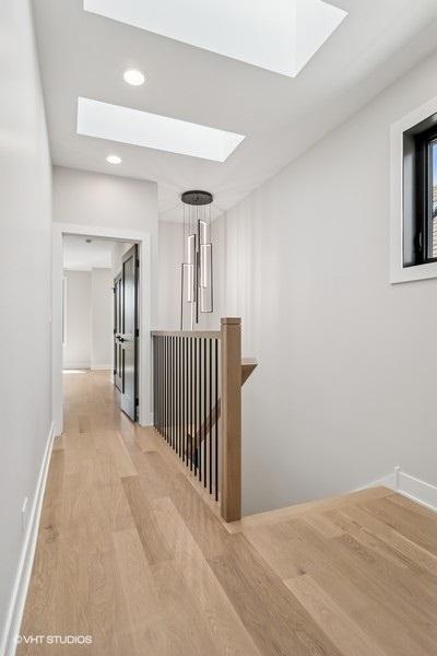 1928 W George St, Chicago, IL 60657 - corridor featuring a skylight, light wood-style flooring, recessed lighting, and an upstairs landing