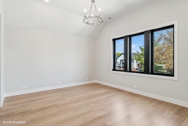 1928 W George St, Chicago, IL 60657 - spare room featuring vaulted ceiling, a chandelier, and light wood-style flooring