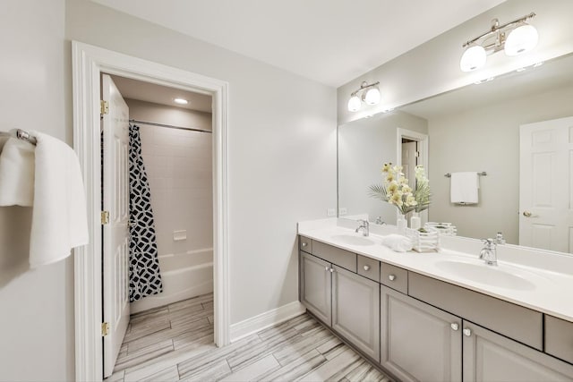 full bathroom with double vanity, baseboards, shower / tub combo, and wood tiled floors