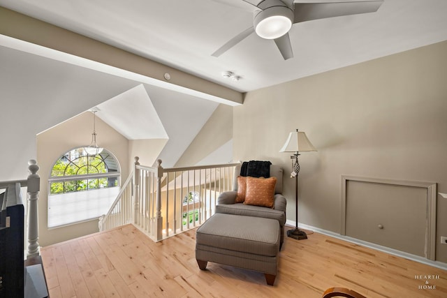 sitting room featuring a ceiling fan, an upstairs landing, wood finished floors, and baseboards
