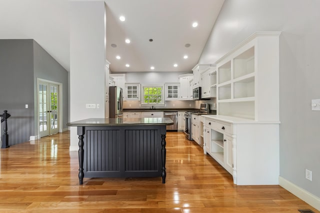 kitchen featuring stainless steel appliances, open shelves, dark countertops, white cabinets, and recessed lighting
