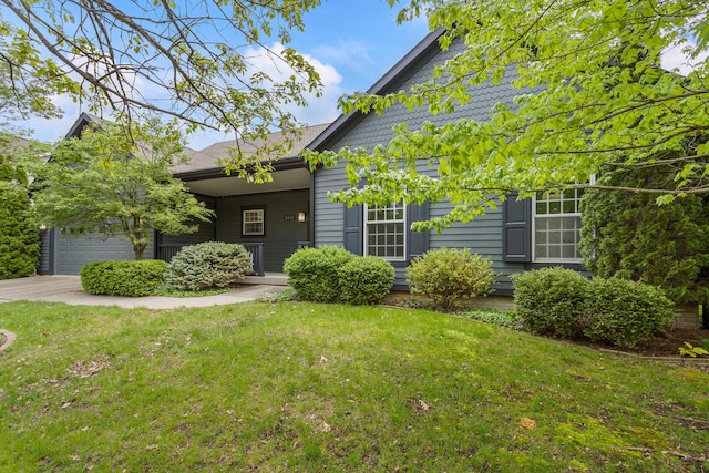 view of front facade featuring a front lawn, covered porch, and a garage