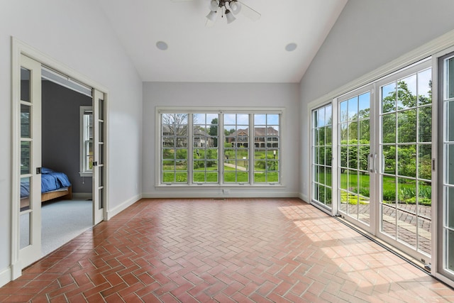 unfurnished sunroom featuring french doors, high vaulted ceiling, baseboards, and brick flooring