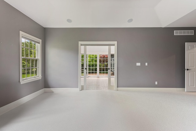 carpeted spare room featuring baseboards
