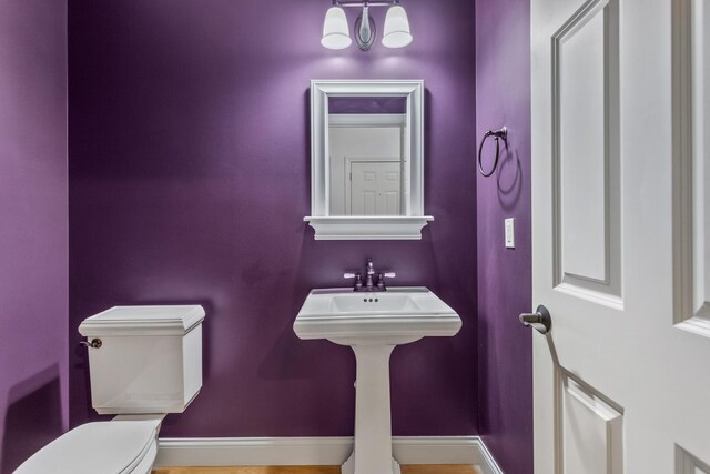 half bath with toilet and baseboards