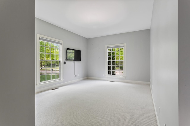 spare room with baseboards and carpet