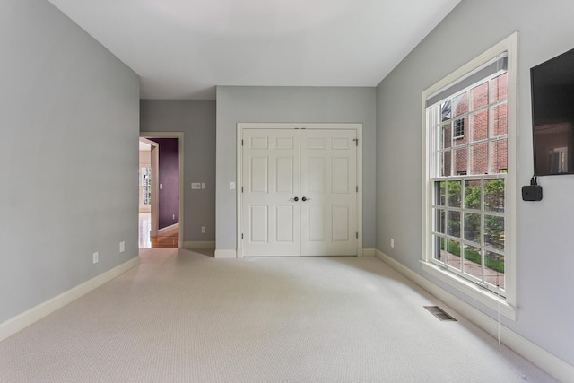 unfurnished bedroom featuring carpet floors, baseboards, and a closet