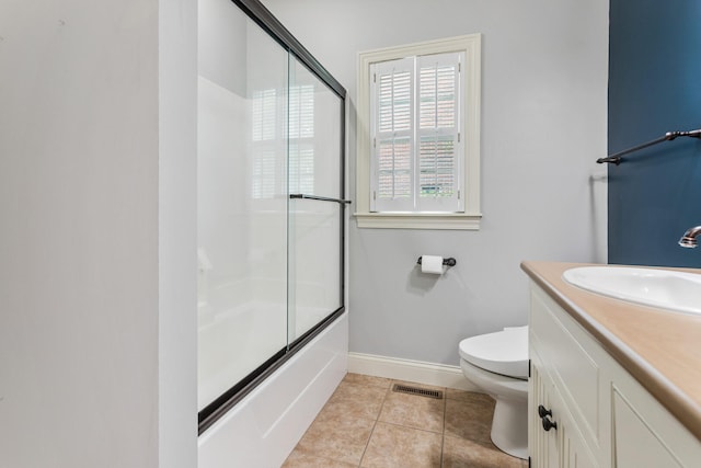 full bath featuring baseboards, vanity, toilet, tile patterned floors, and enclosed tub / shower combo