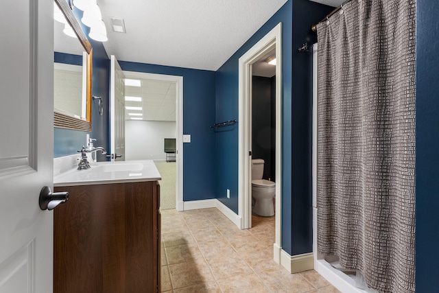 bathroom featuring toilet, tile patterned floors, vanity, a shower stall, and baseboards