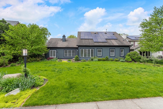 back of house featuring solar panels and a chimney