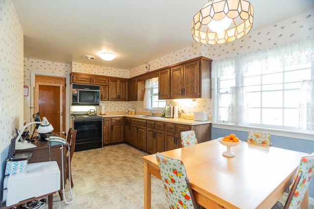 9450 Greenwood Ave, Des Plaines, IL 60016 - kitchen featuring black gas range, wallpapered walls, light countertops, a sink, and light floors