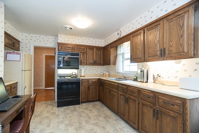9450 Greenwood Ave, Des Plaines, IL 60016 - kitchen featuring wallpapered walls, black appliances, light countertops, light flooring, and a sink