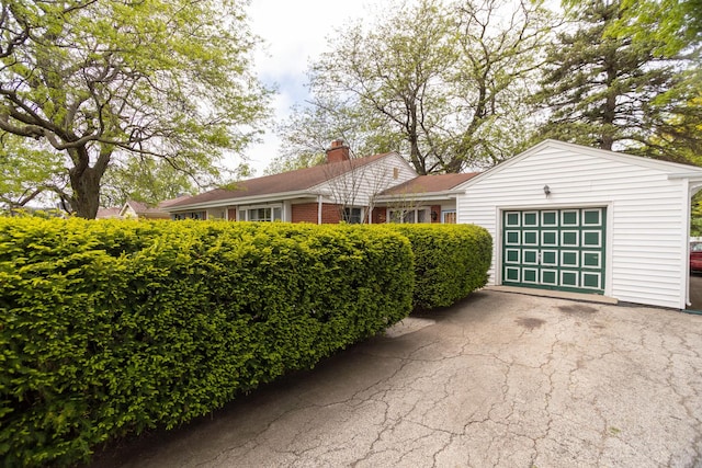 9450 Greenwood Ave, Des Plaines, IL 60016 - view of front of home with a garage, a chimney, and driveway