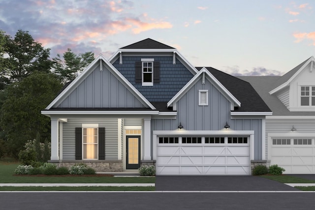view of front of house featuring board and batten siding, stone siding, and aphalt driveway