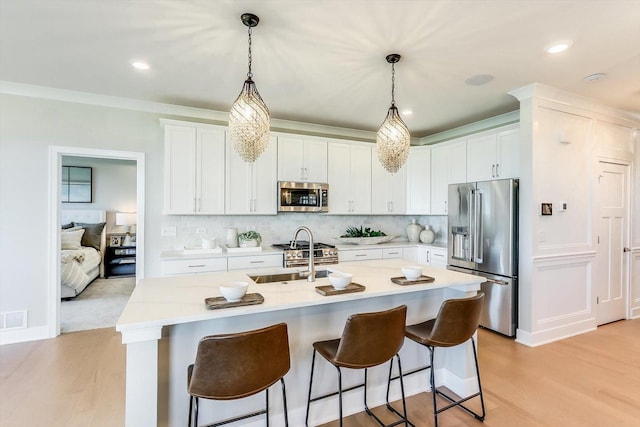 kitchen featuring light countertops, stainless steel appliances, a sink, and light wood-style floors
