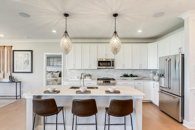 kitchen featuring stainless steel appliances, tasteful backsplash, a sink, and a kitchen bar