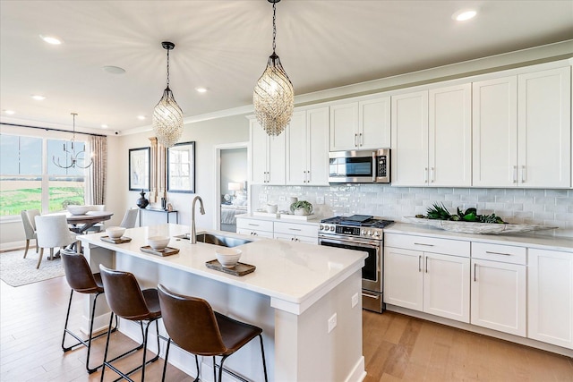 kitchen featuring an inviting chandelier, a sink, appliances with stainless steel finishes, and backsplash
