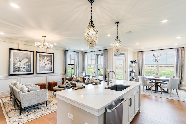 kitchen featuring a sink, light wood-style flooring, a chandelier, and a healthy amount of sunlight