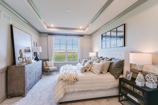 bedroom with visible vents, a raised ceiling, crown molding, and light carpet