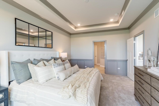 bedroom with visible vents, wainscoting, recessed lighting, light colored carpet, and a tray ceiling