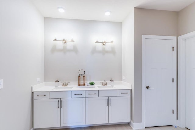full bathroom with a sink and double vanity