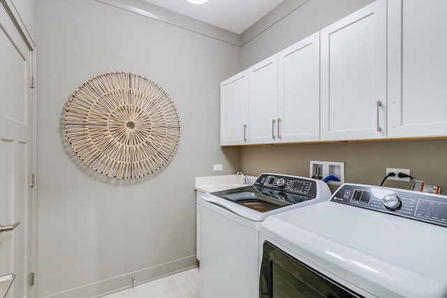 laundry area featuring baseboards, a sink, cabinet space, and washing machine and dryer