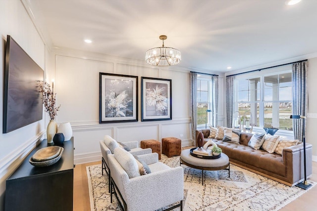living area with an inviting chandelier, recessed lighting, a decorative wall, and wood finished floors