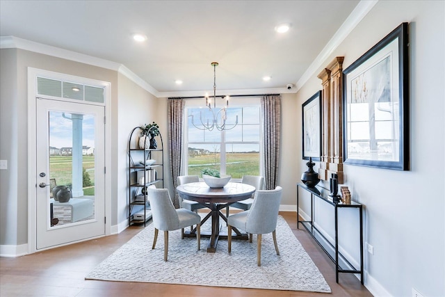 dining space with an inviting chandelier, ornamental molding, and baseboards