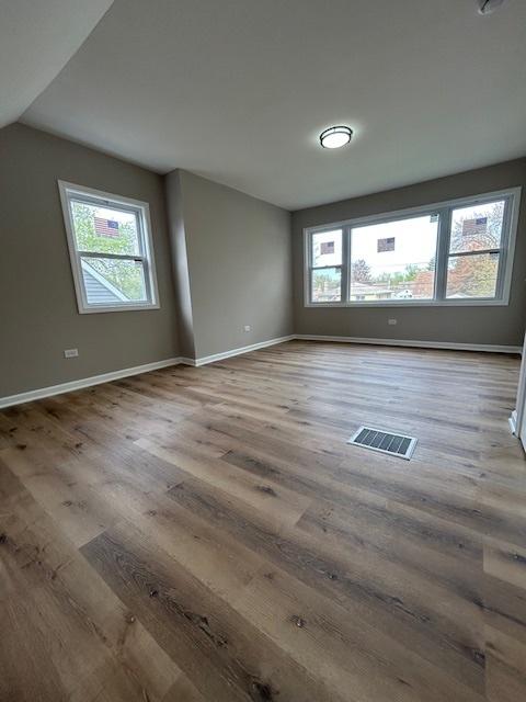 1473 Wentworth Ave, Calumet City, IL 60409 - unfurnished room with plenty of natural light, wood finished floors, and lofted ceiling