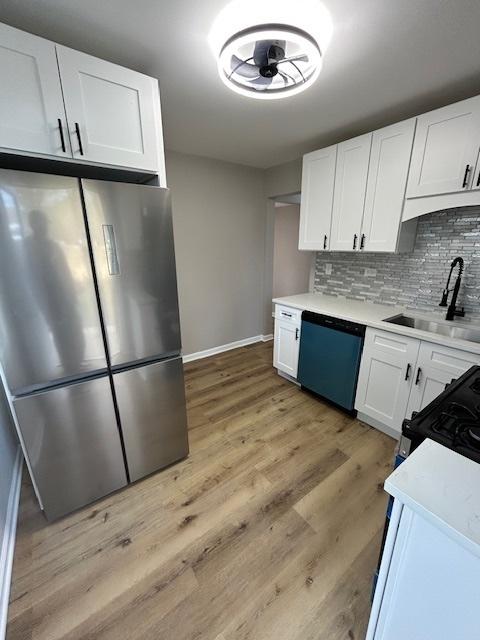1473 Wentworth Ave, Calumet City, IL 60409 - kitchen with freestanding refrigerator, dishwashing machine, white cabinets, backsplash, and light countertops