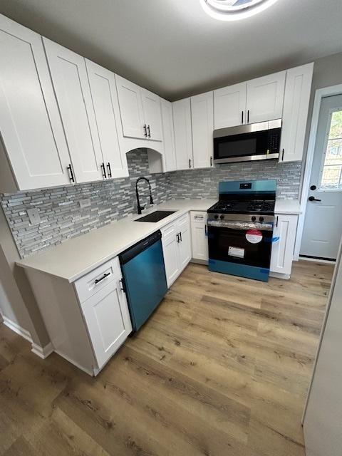 1473 Wentworth Ave, Calumet City, IL 60409 - kitchen with stainless steel appliances, light countertops, backsplash, and white cabinets