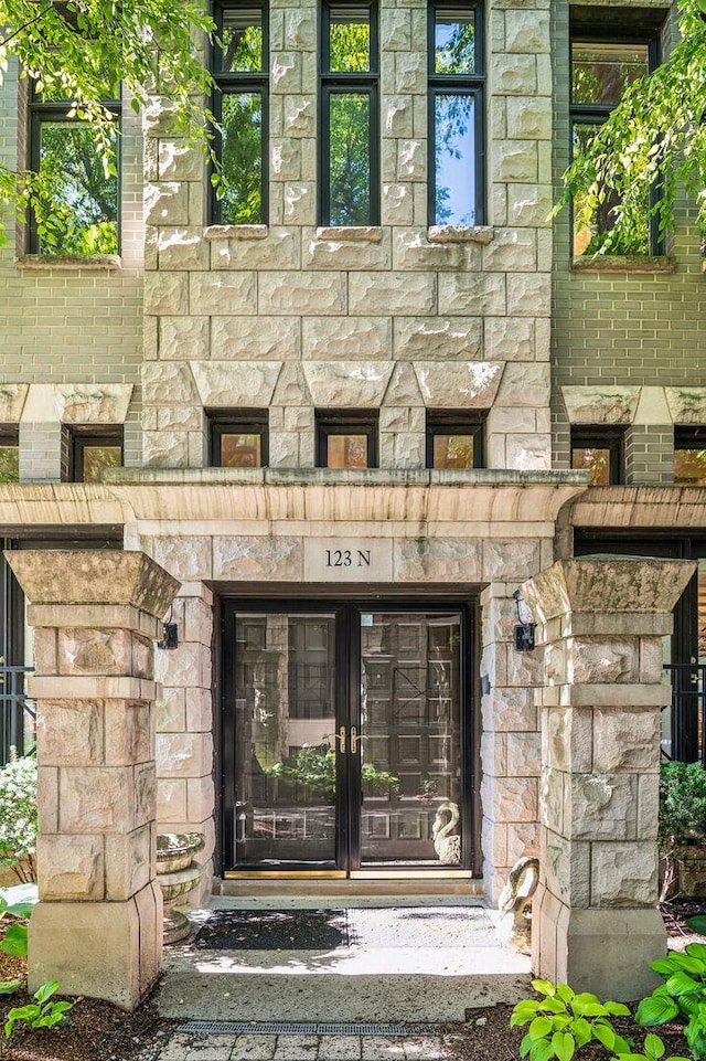 doorway to property featuring french doors and stone siding