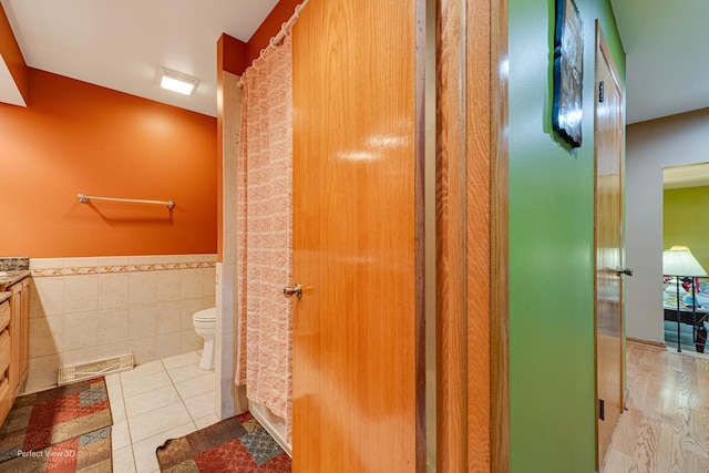 400 Illinois Rd, Frankfort, IL 60423 - full bath featuring vanity, a wainscoted wall, toilet, tile walls, and tile patterned flooring