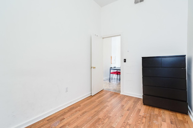 1449 N Artesian Ave, Chicago, IL 60622 - unfurnished bedroom with light wood-type flooring, baseboards, a towering ceiling, and visible vents
