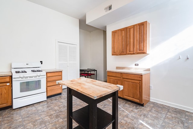 1449 N Artesian Ave, Chicago, IL 60622 - kitchen with light countertops, gas range gas stove, brown cabinets, and visible vents