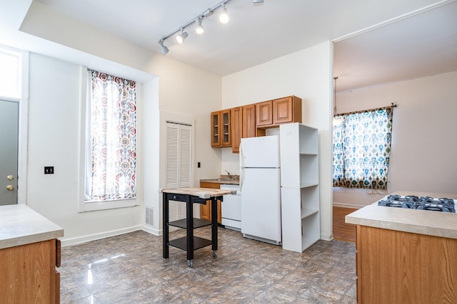 1449 N Artesian Ave, Chicago, IL 60622 - kitchen with brown cabinetry, rail lighting, a sink, glass insert cabinets, and white appliances