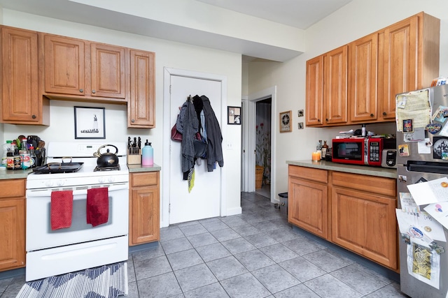 1449 N Artesian Ave, Chicago, IL 60622 - kitchen with white gas range oven, light tile patterned floors, freestanding refrigerator, and light countertops