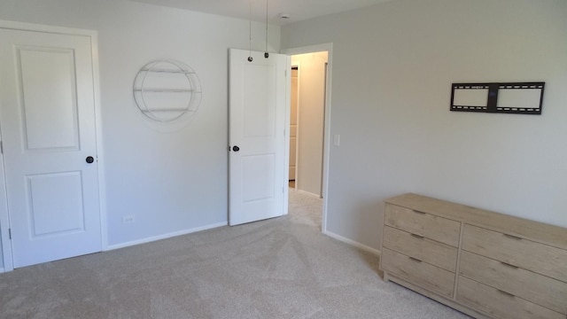 unfurnished bedroom featuring light colored carpet and baseboards