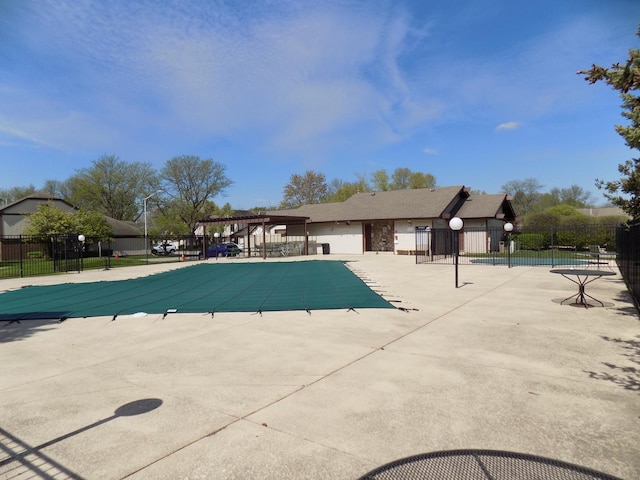 community pool featuring fence and a patio
