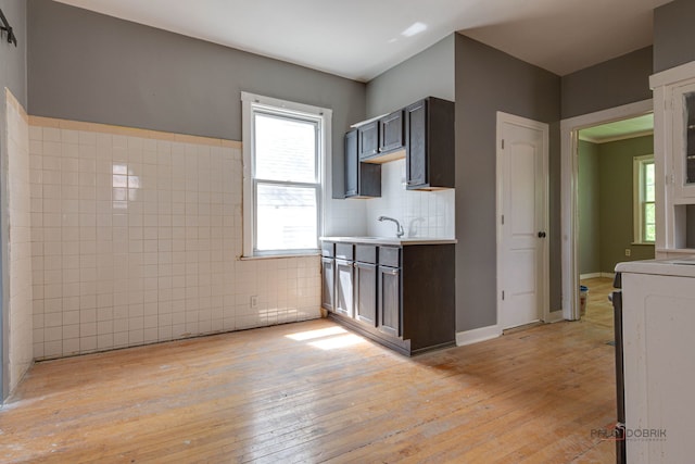 3117 S 53rd Ave, Cicero, IL 60804 - kitchen featuring light wood-style floors, stove, light countertops, dark brown cabinets, and tile walls