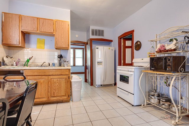 3117 S 53rd Ave, Cicero, IL 60804 - kitchen with white appliances, light countertops, decorative backsplash, a sink, and light tile patterned floors