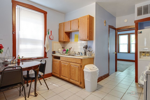 3117 S 53rd Ave, Cicero, IL 60804 - kitchen with light countertops, decorative backsplash, white refrigerator with ice dispenser, light tile patterned flooring, and baseboards