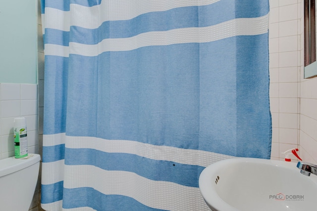 3117 S 53rd Ave, Cicero, IL 60804 - full bathroom with tile walls, a sink, toilet, and a shower with shower curtain