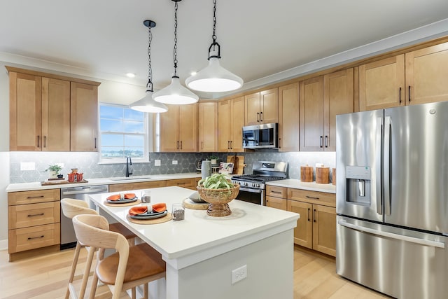 kitchen with light brown cabinetry, a sink, light wood-style floors, light countertops, and stainless steel appliances