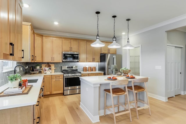 kitchen with light brown cabinetry, a sink, light wood finished floors, stainless steel appliances, and backsplash