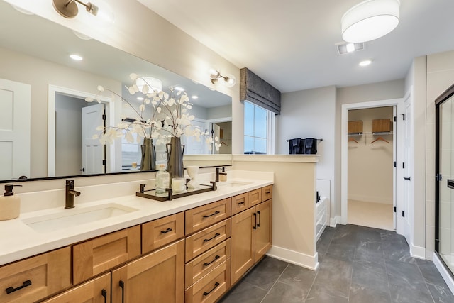 bathroom with a sink, a stall shower, double vanity, and a spacious closet