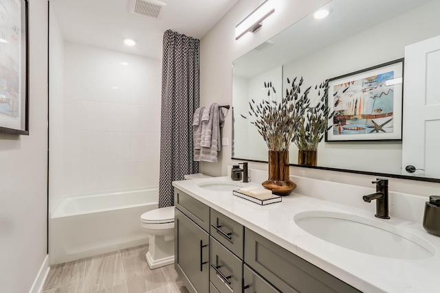 full bath featuring double vanity, toilet, visible vents, and a sink