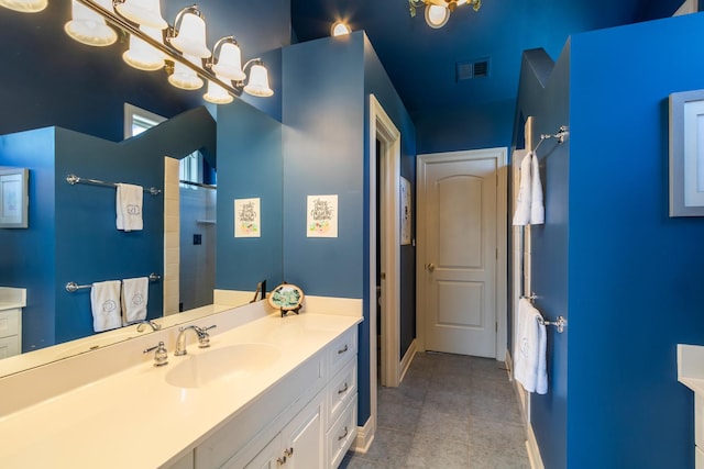 bathroom featuring baseboards, vanity, tile patterned floors, and a shower